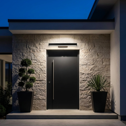 Rectangular LED light glowing above a modern front door at night